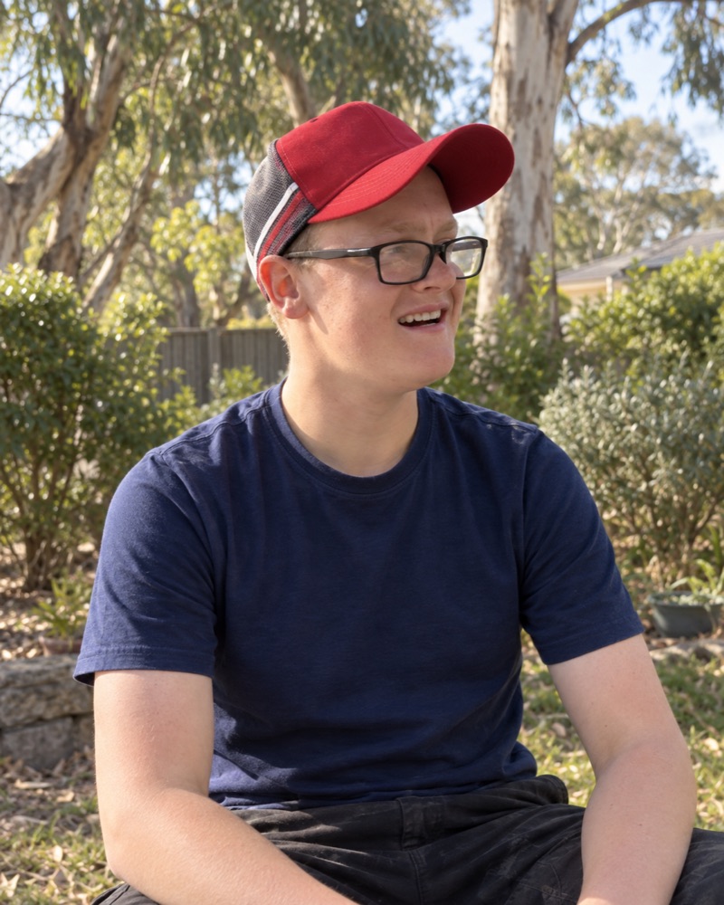 Illustrated portrait of Jack in a red cap, smiling in a garden